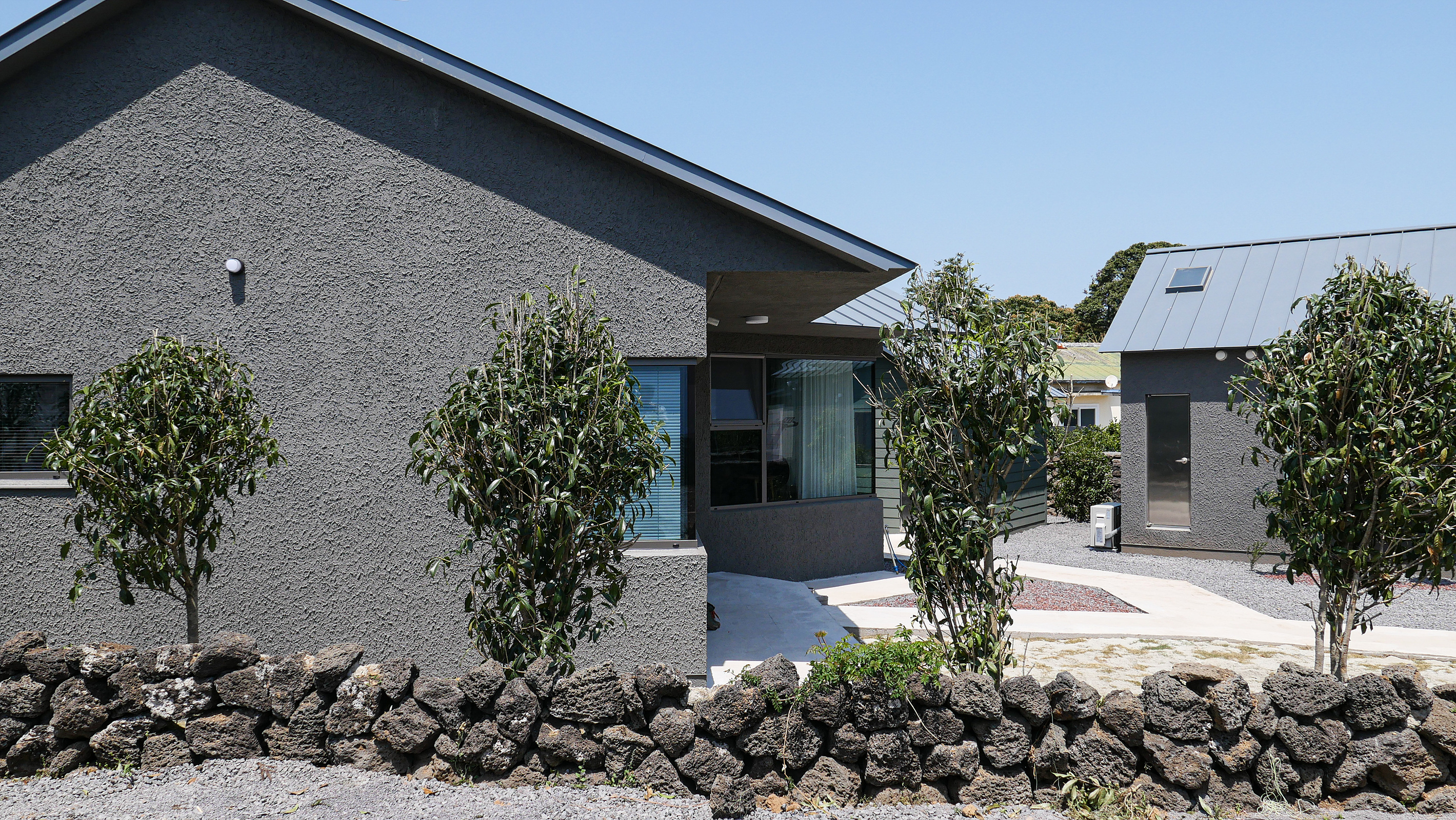 A concrete single-story house designed by BYHAND at dusk